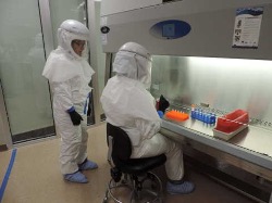 People wearing high containment lab wear in a laboratory